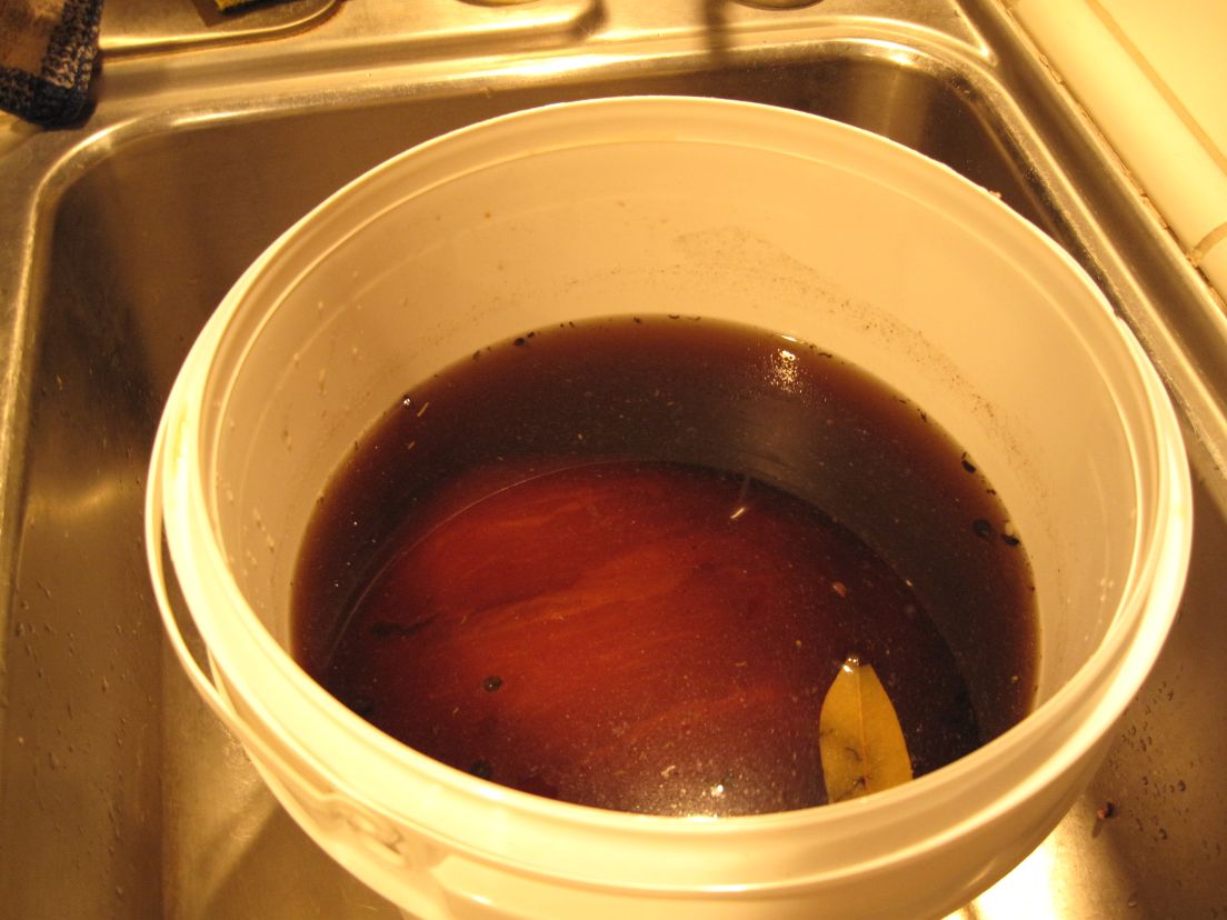 ham covered in brine in white bucket