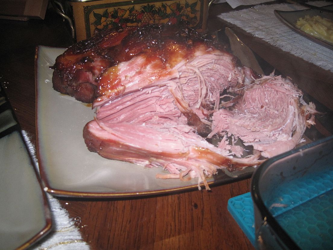 Honey glazed gammon served on a plate in the middle of the dining room table