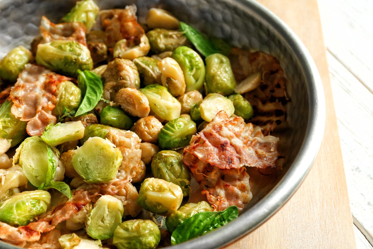 Frying pan with Brussels sprouts and bacon, closeup