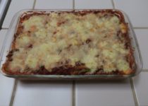 Pan of fresh cooked lasagna on a tile counter