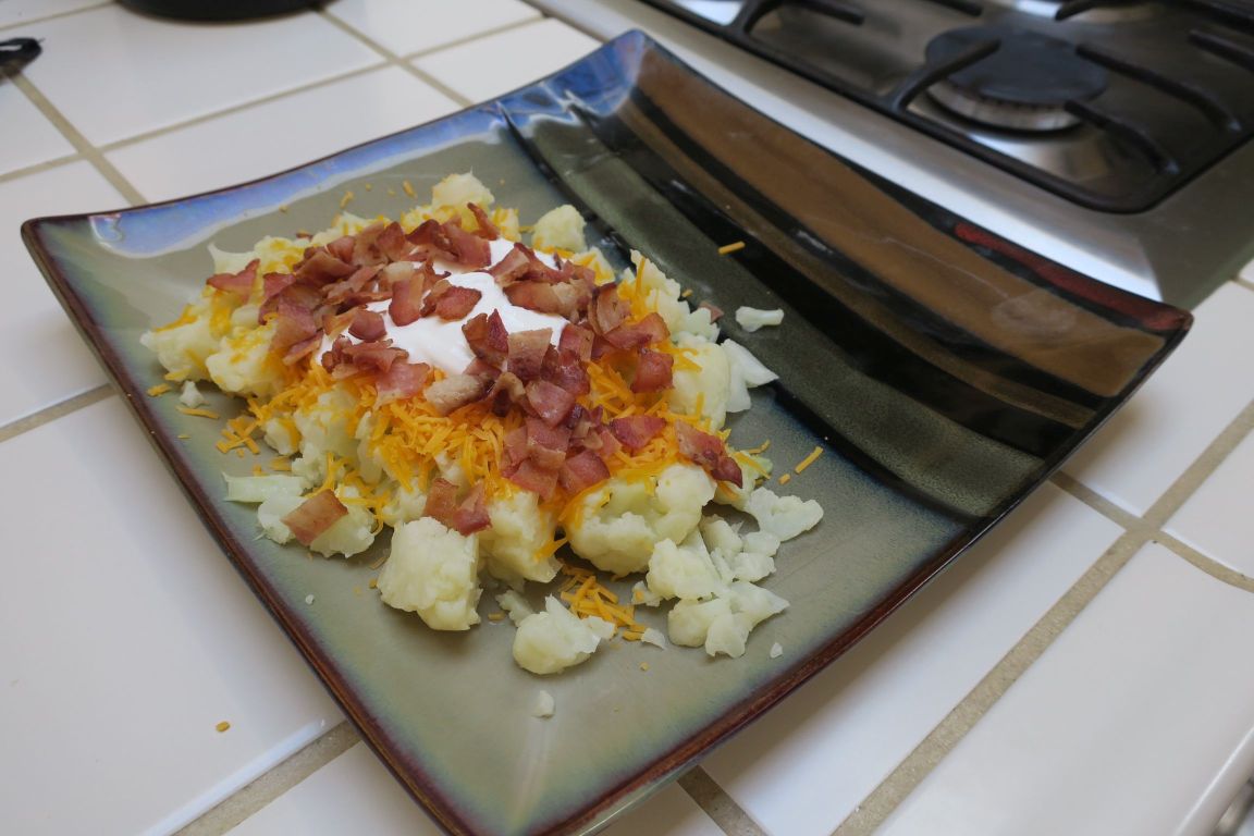 loaded cauliflower is just chopped, cooked cauliflower topped with cheese, bacon, and sour cream