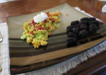 Confetti eggs are made with colorful vegetables and topped with taco sauce and sour cream.