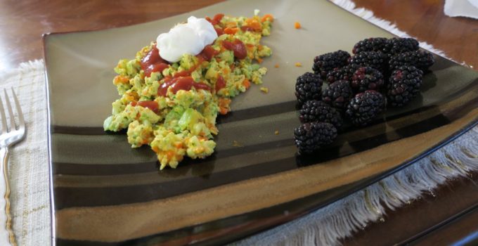 Confetti eggs are made with colorful vegetables and topped with taco sauce and sour cream.