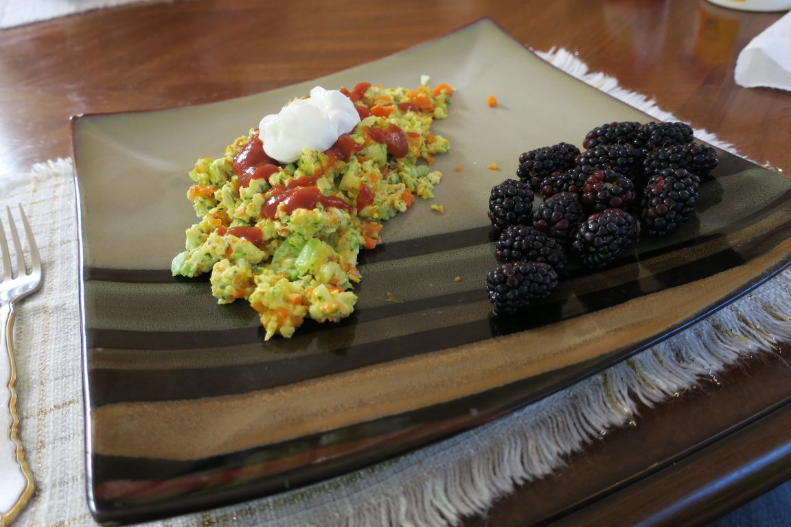 Confetti eggs are made with colorful vegetables and topped with taco sauce and sour cream.