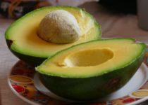 avocado cut in half and sitting on a plate
