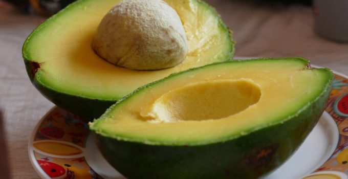 avocado cut in half and sitting on a plate