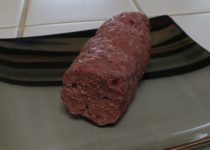 cooked and cut spicy beef log on a plate