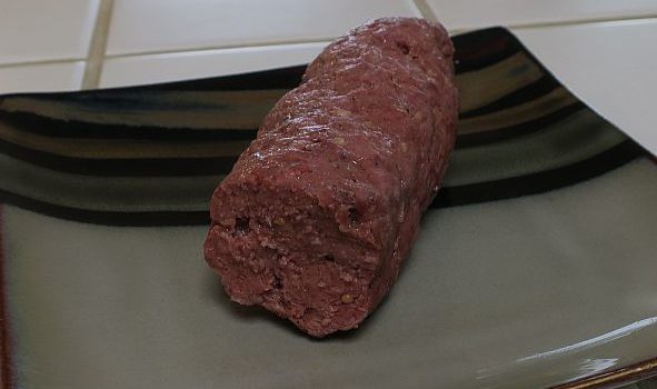 cooked and cut spicy beef log on a plate