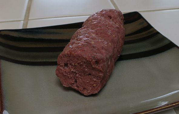 cooked and cut spicy beef log on a plate