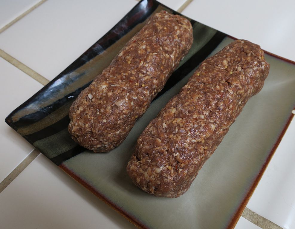 raw shaped spicy beef logs on a plate