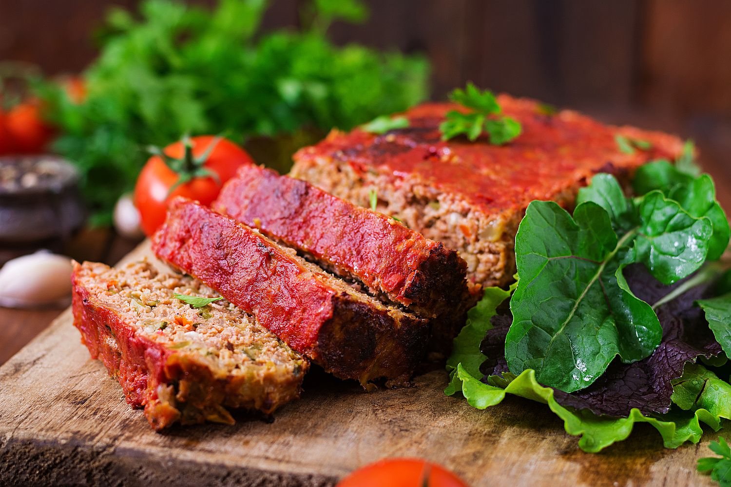 Homemade meatloaf with savory topping on wooden board
