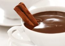 dark hot chocolate in white cups with cinnamon stick