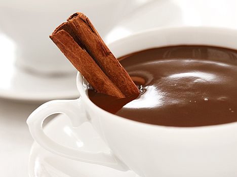 dark hot chocolate in white cups with cinnamon stick