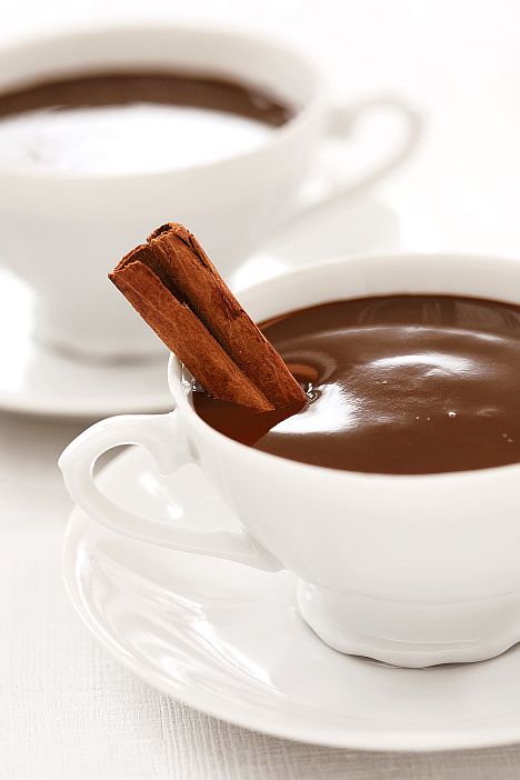 dark hot chocolate in white cups with cinnamon stick