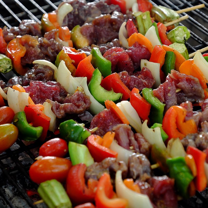 colorful meat and vegetable kabobs on a grill