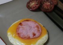 egg stack on a plate with sliced heirloom tomatoes