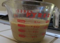 fresh white mushroom gravy in a measuring cup