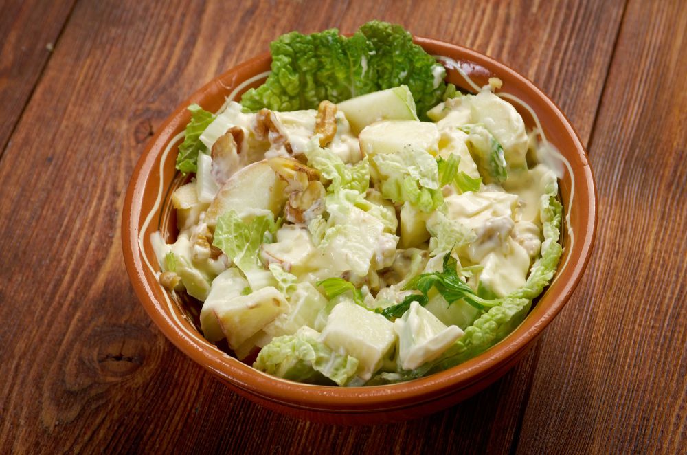 classic Waldorf salad with apples, celery, walnuts, and mayo in a brown bow.