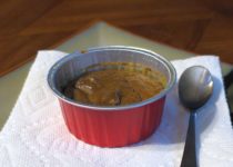 individual gluten-free pumpkin pie custard in a red ramekin on a white napkin